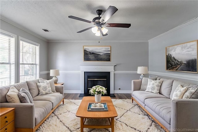 7384 Birch Hollow Pl, Douglasville, GA 30134 - living room featuring wood finished floors, ceiling fan, ornamental molding, a fireplace with flush hearth, and baseboards
