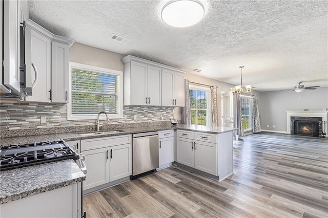 48 Savanna Ct, Powder Springs, GA 30127 - kitchen featuring dishwasher, a sink, open floor plan, a peninsula, and light wood-style floors