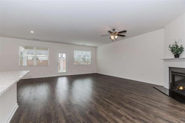 977 Daurian Dr, Statham, GA 30666 - unfurnished living room featuring dark wood-style flooring, a glass covered fireplace, ceiling fan, and recessed lighting