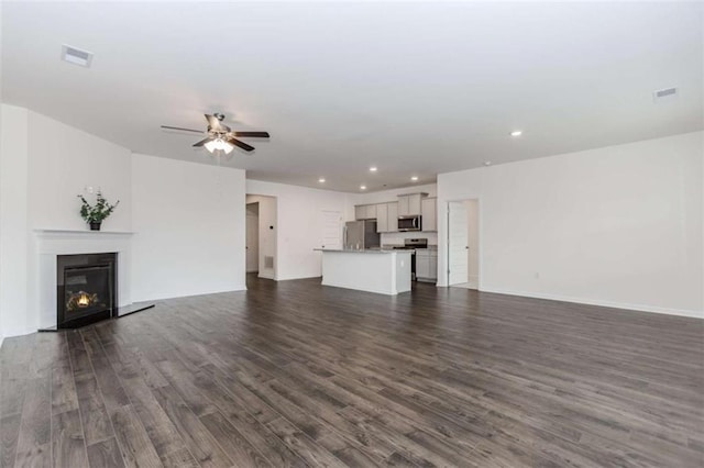 977 Daurian Dr, Statham, GA 30666 - unfurnished living room with ceiling fan, dark wood-style flooring, recessed lighting, and a glass covered fireplace