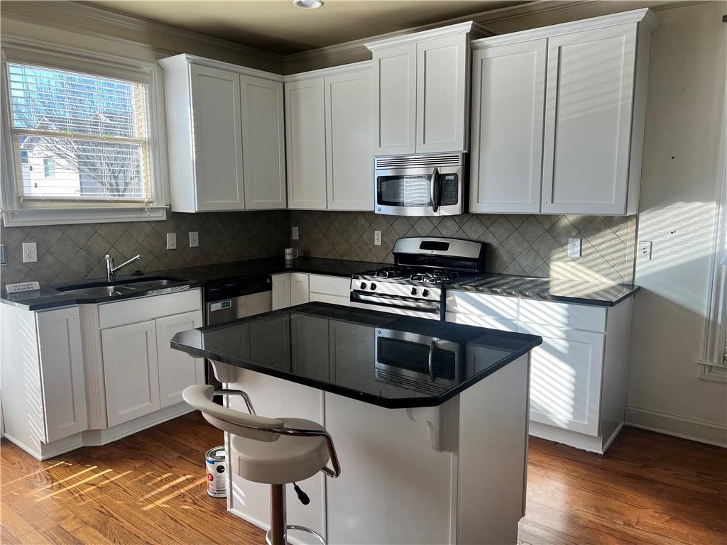 kitchen featuring sink, white cabinets, hardwood / wood-style floors, and stainless steel appliances