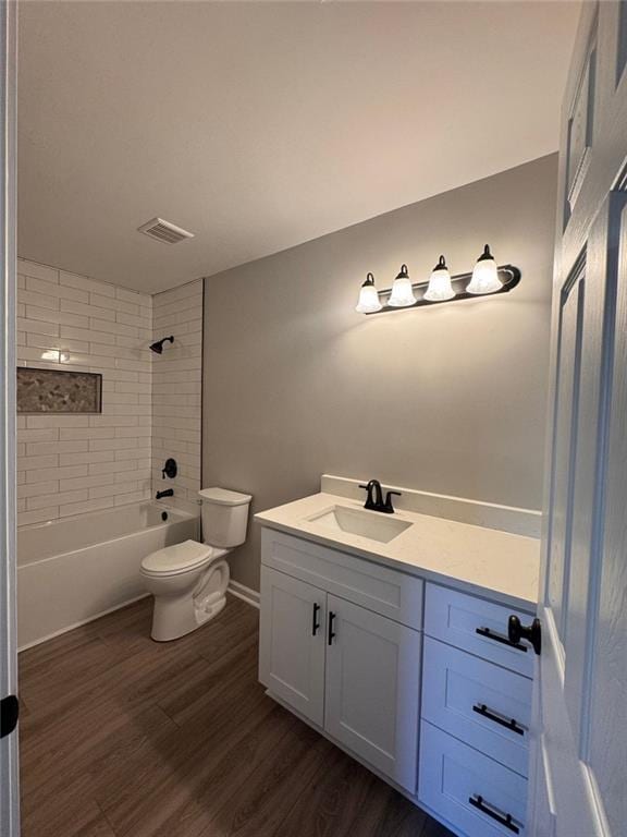 full bathroom featuring vanity, toilet, hardwood / wood-style floors, and tiled shower / bath