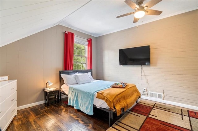 bedroom featuring dark wood-type flooring, ceiling fan, vaulted ceiling, and wood walls