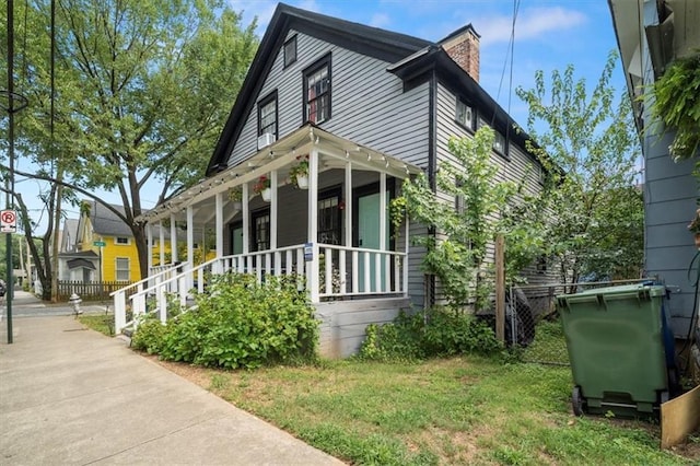 view of side of home with a porch and a lawn