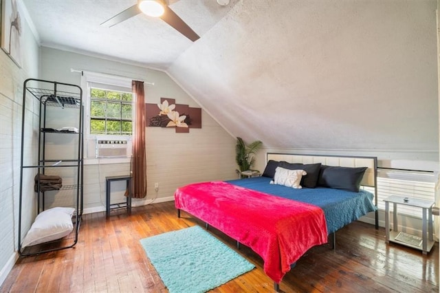 bedroom featuring ceiling fan, cooling unit, hardwood / wood-style flooring, and vaulted ceiling