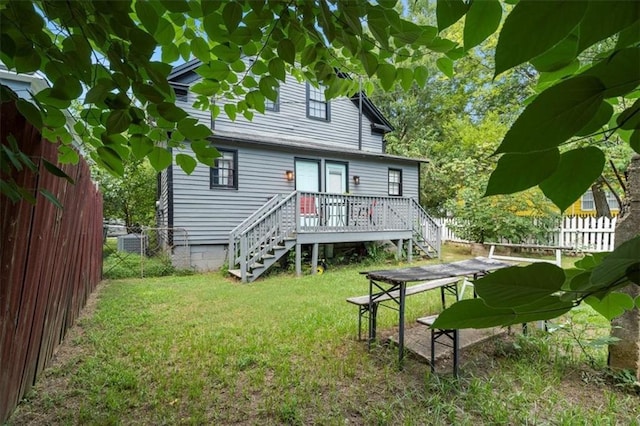 rear view of house featuring a wooden deck and a yard