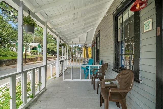 unfurnished sunroom with vaulted ceiling with beams