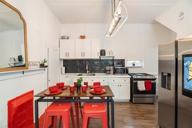 kitchen featuring white cabinets, dark hardwood / wood-style flooring, stainless steel appliances, decorative backsplash, and sink