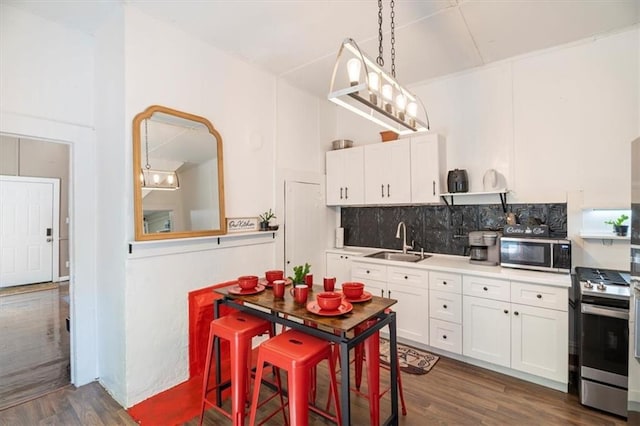 kitchen with appliances with stainless steel finishes, decorative backsplash, white cabinets, and sink