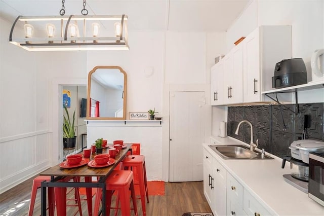 kitchen with white cabinetry, pendant lighting, dark hardwood / wood-style floors, and sink