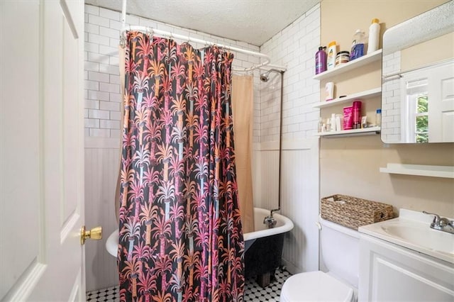 full bathroom with toilet, vanity, shower / bath combo, and a textured ceiling