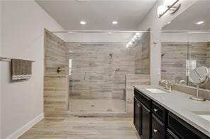 bathroom featuring vanity, wood-type flooring, and a tile shower