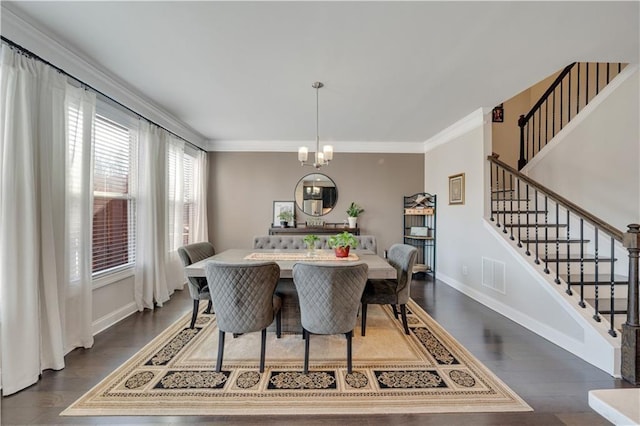 dining space with an inviting chandelier, crown molding, and dark wood-type flooring