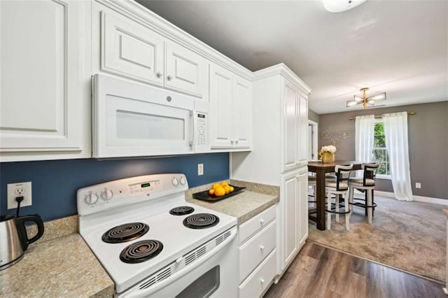 330 Pitts Chapel Rd, Newborn, GA 30056 - kitchen with white cabinets, dark wood finished floors, a chandelier, white appliances, and light countertops