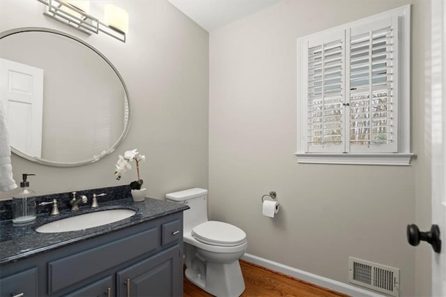 bathroom featuring vanity, toilet, and hardwood / wood-style floors