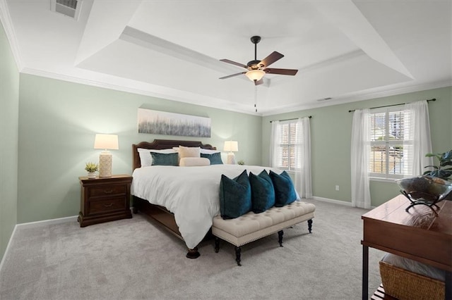 carpeted bedroom with a raised ceiling, ornamental molding, and ceiling fan