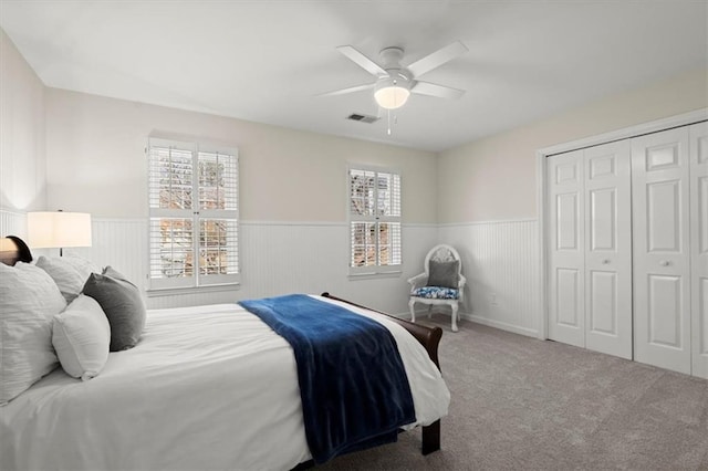 carpeted bedroom featuring ceiling fan and a closet