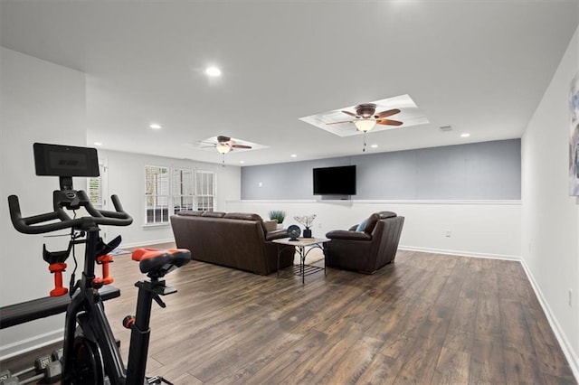 exercise area with ceiling fan, dark hardwood / wood-style flooring, and a skylight