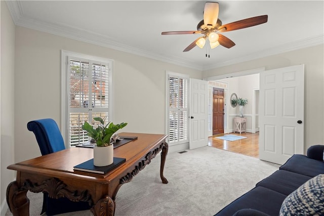 office space featuring ceiling fan, ornamental molding, and light carpet