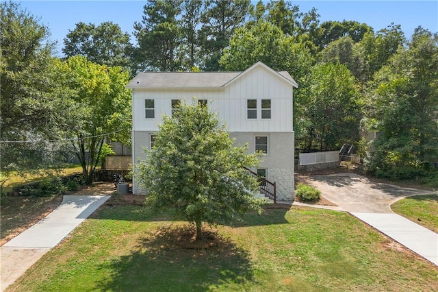 view of front of home with a front lawn, central air condition unit, and board and batten siding