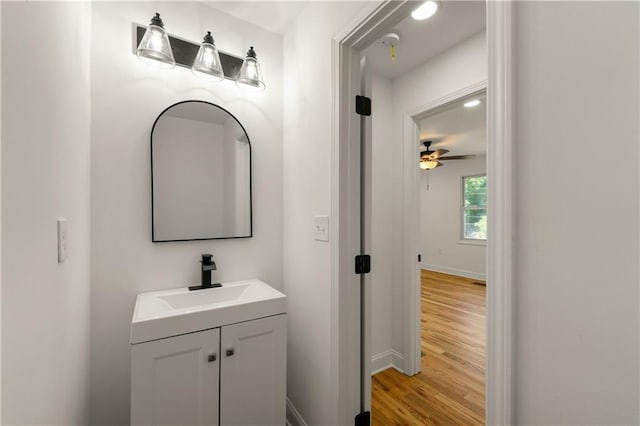 bathroom with baseboards, wood finished floors, and vanity