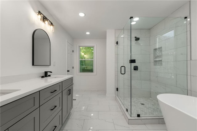 bathroom featuring double vanity, a freestanding bath, a sink, a shower stall, and marble finish floor