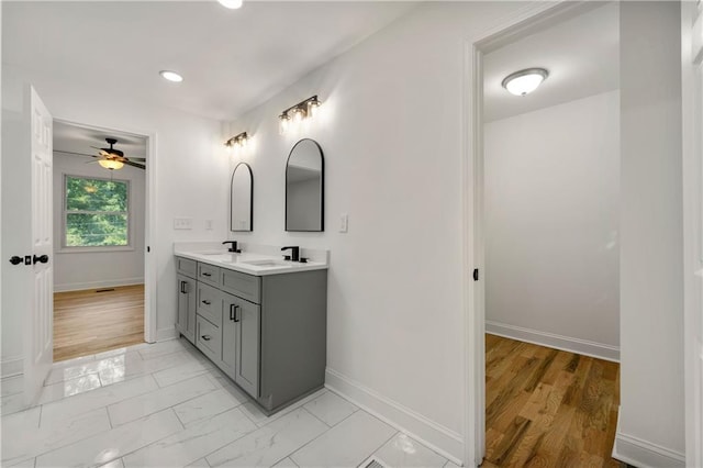 bathroom featuring baseboards, double vanity, recessed lighting, a sink, and marble finish floor