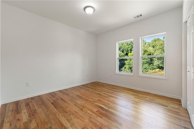 empty room with visible vents, baseboards, and light wood-style floors