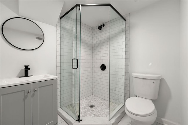 bathroom featuring visible vents, toilet, a stall shower, baseboards, and vanity