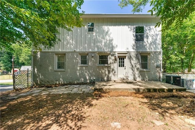 colonial house featuring cooling unit, a patio, and brick siding