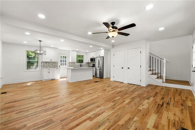 unfurnished living room with recessed lighting, stairway, ceiling fan, and light wood-style floors