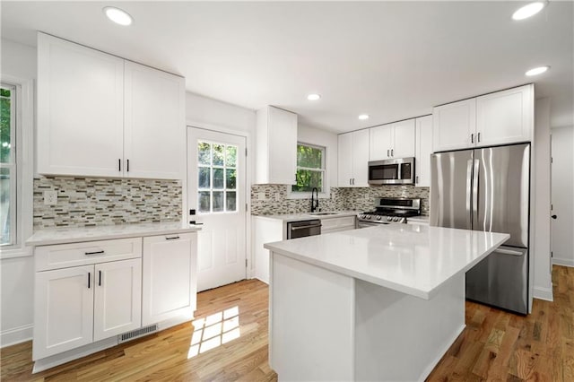 kitchen featuring visible vents, light wood finished floors, appliances with stainless steel finishes, white cabinets, and light countertops