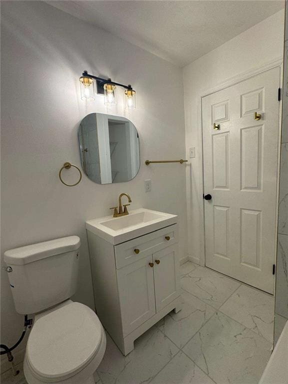 bathroom featuring marble finish floor, vanity, and toilet