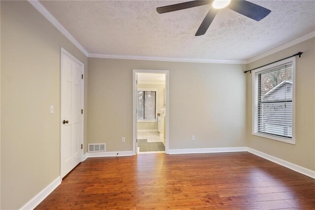 spare room featuring hardwood / wood-style floors, ceiling fan, crown molding, and a textured ceiling