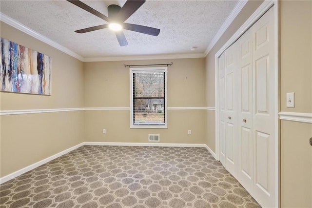 empty room featuring ceiling fan, ornamental molding, and a textured ceiling