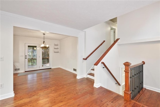 interior space featuring a chandelier, wood-type flooring, and crown molding