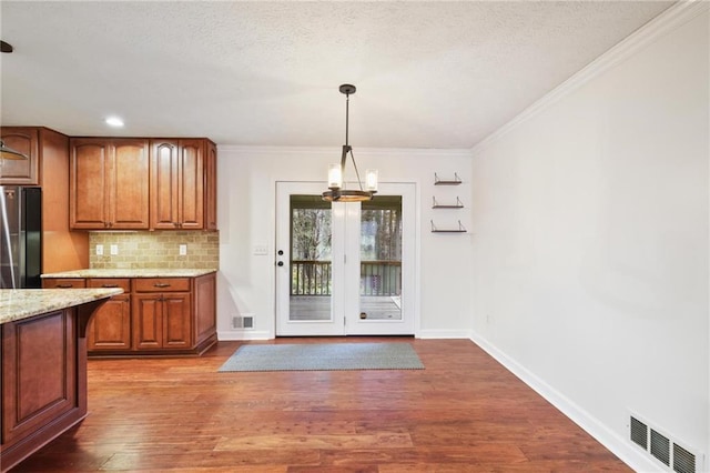 unfurnished dining area with hardwood / wood-style floors and crown molding