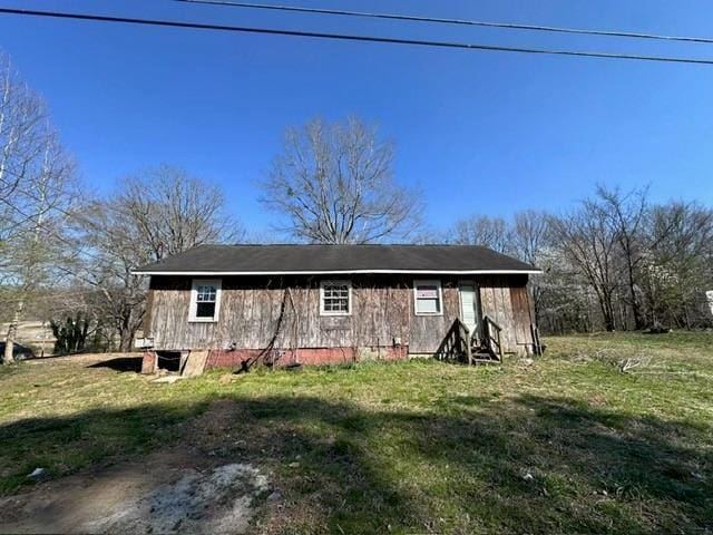 rear view of house featuring a yard