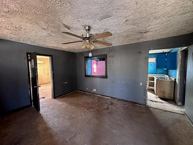 spare room featuring a textured ceiling and ceiling fan