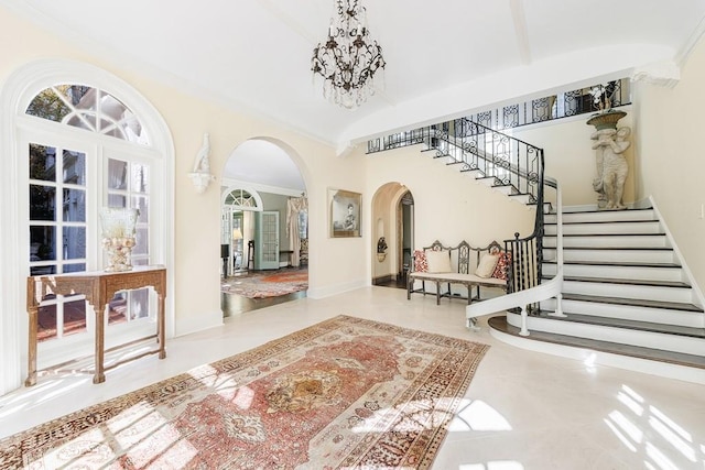 foyer entrance featuring tile patterned floors, french doors, a high ceiling, and an inviting chandelier