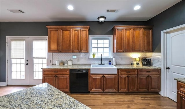 kitchen featuring hardwood / wood-style flooring, dishwasher, sink, and decorative backsplash