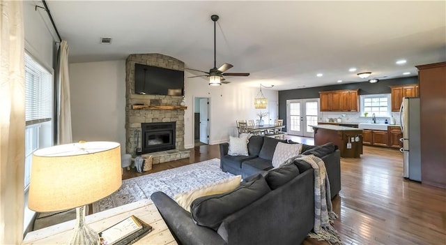 living room with sink, dark wood-type flooring, a fireplace, and french doors