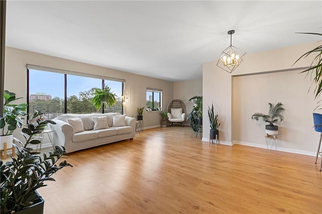 living room with light hardwood / wood-style floors and a notable chandelier