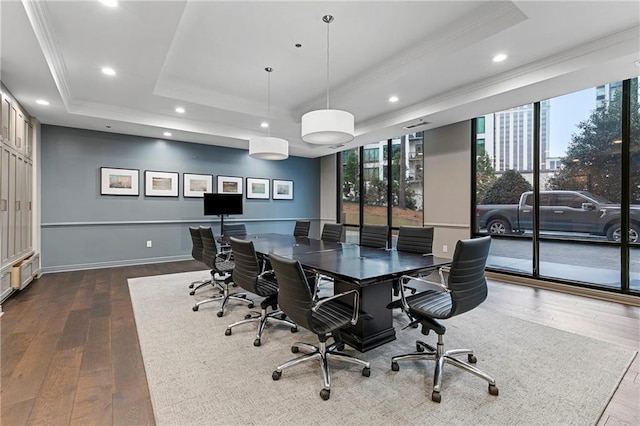 home office with a tray ceiling, ornamental molding, and hardwood / wood-style flooring