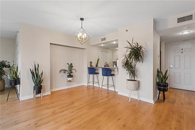 entrance foyer with light hardwood / wood-style floors and a chandelier