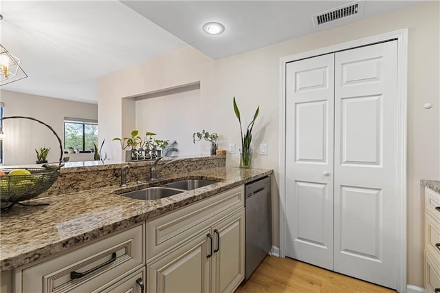 kitchen with sink, light wood-type flooring, stainless steel dishwasher, and light stone countertops