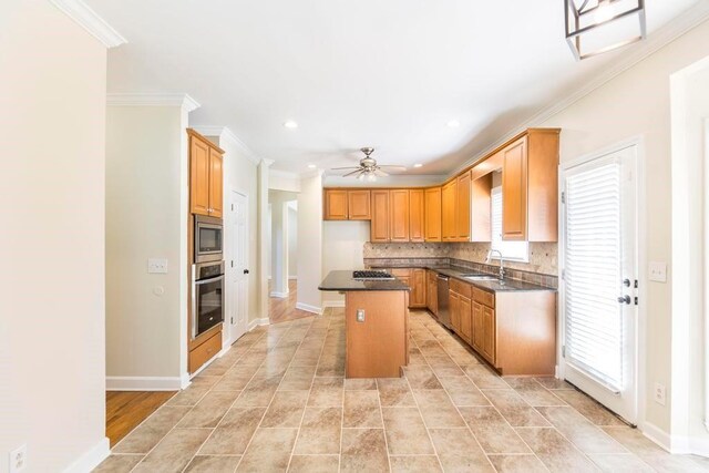 100 Bentwood Cir, Macon, GA 31210 - kitchen with appliances with stainless steel finishes, crown molding, a sink, a center island, and dark countertops