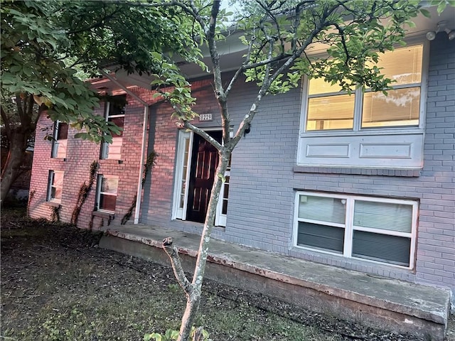 doorway to property featuring brick siding