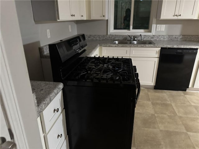 kitchen with black appliances, a sink, white cabinetry, and glass insert cabinets