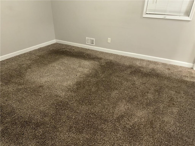 carpeted empty room featuring baseboards